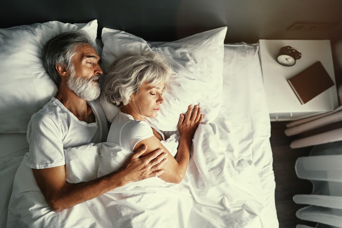 a couple sleeping together in bed