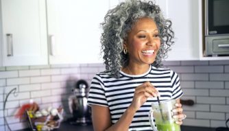 mature woman drinking a healthy green smoothie