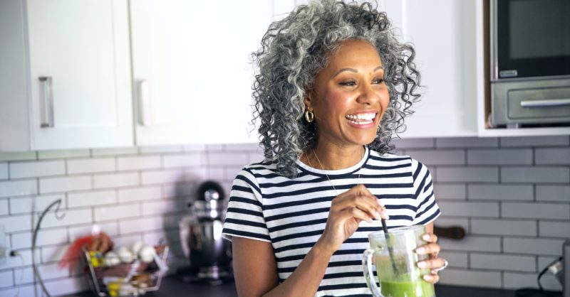 mature woman drinking a healthy green smoothie