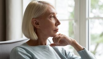 Woman sitting on chair looking out the window