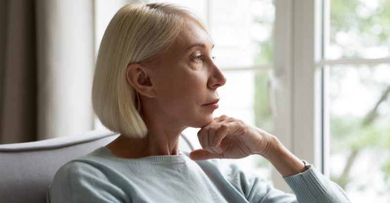 Woman sitting on chair looking out the window