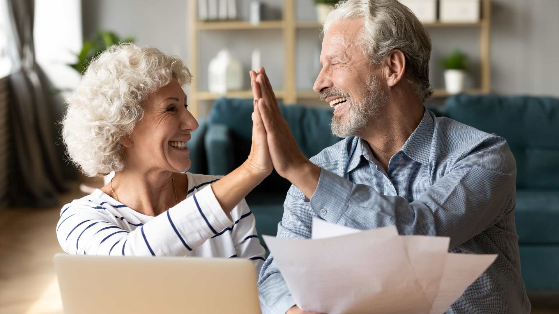 Older couple high-fiving over documents